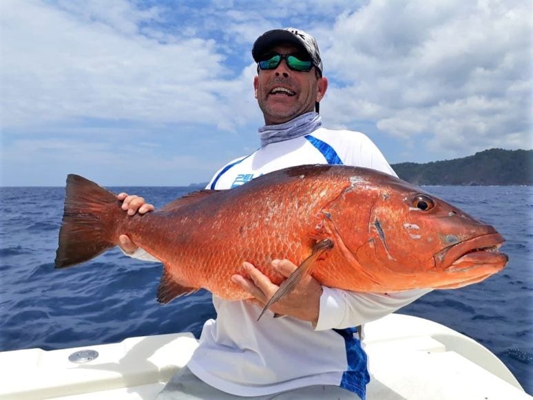 angler holding cubera snapper