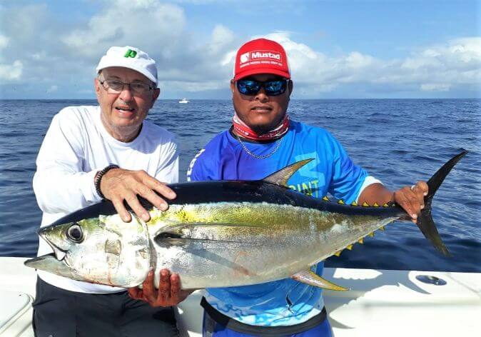 Mate and angler posing with small yellowfin tuna.