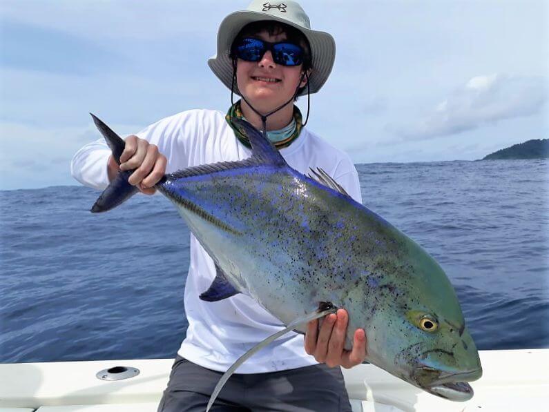 Angler posing with Bluefin Trevally