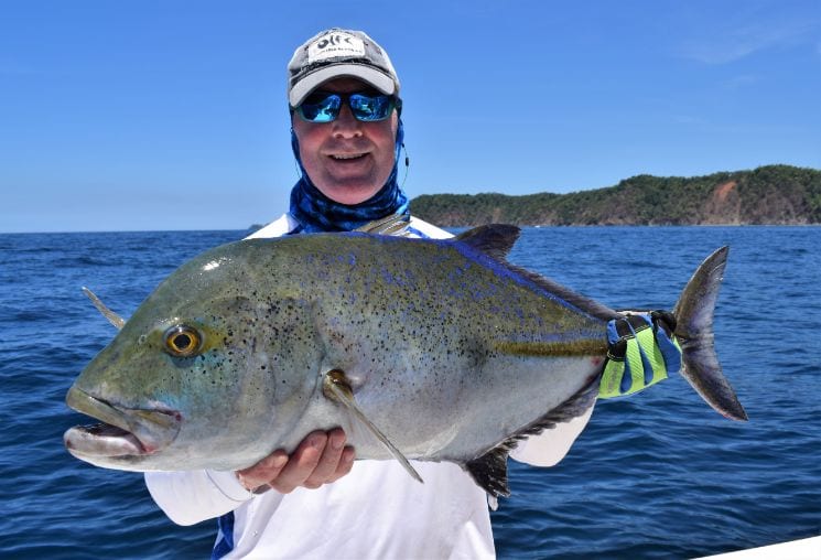 Angler posing with Bluefin Trevally