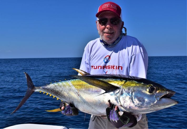 Angler posing with yellowfin tuna