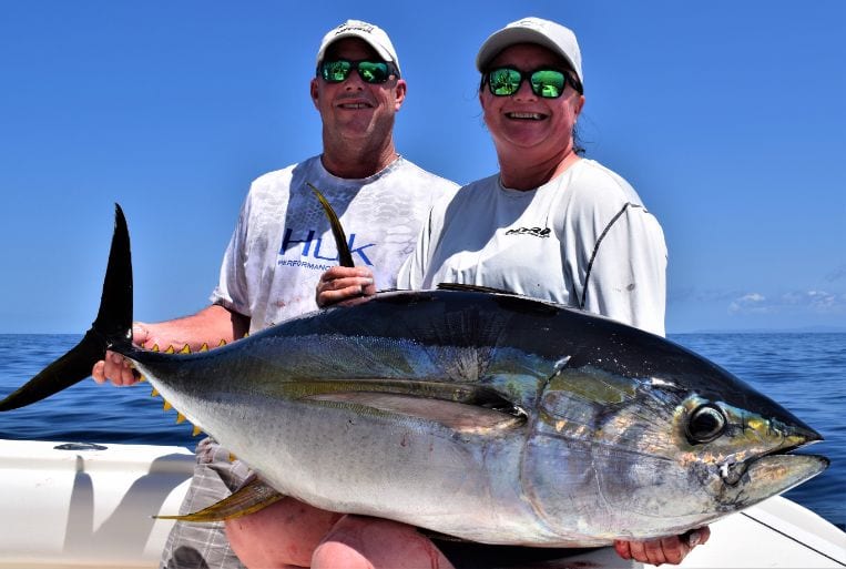 Two smiling anglers holding 90 pound yellowfin tuna