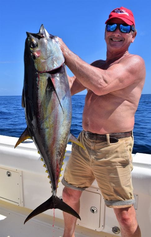 Angler posing for picture holding Yellowfin Tuna