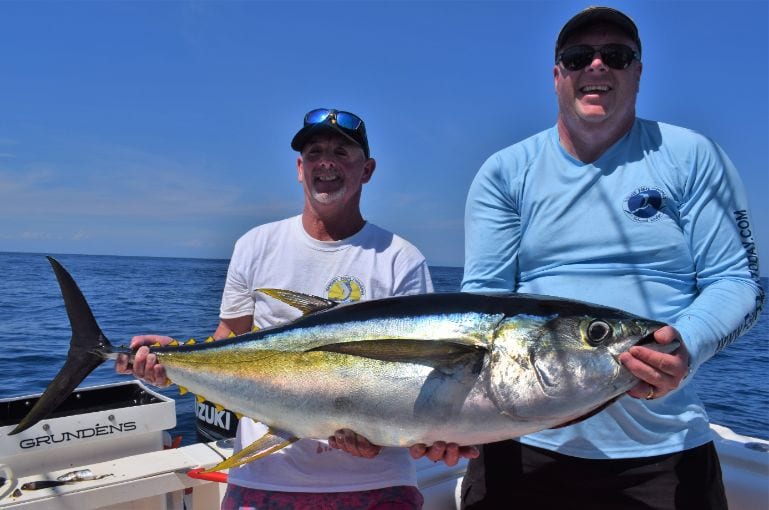 Two smiling anglers holding nice yellowfin tuna