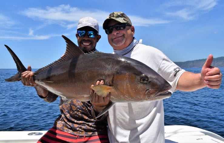 Mate holding a snapper with angler giving thumbs up