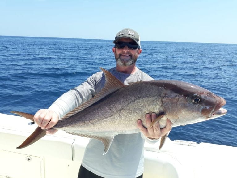 Angler posing for picture holding crevalle jack