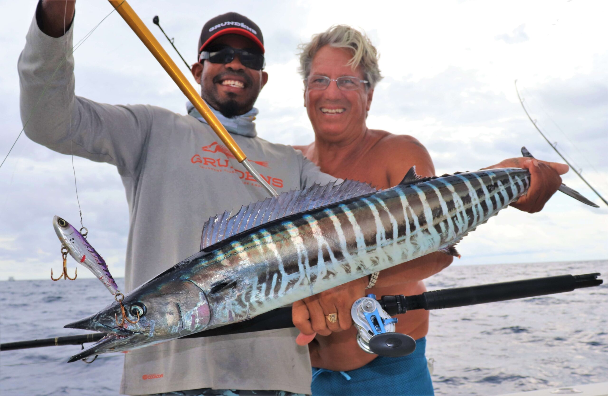 two men holding wahoo fish in panama