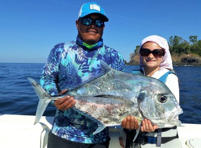 Mate holding African pompano for young angler