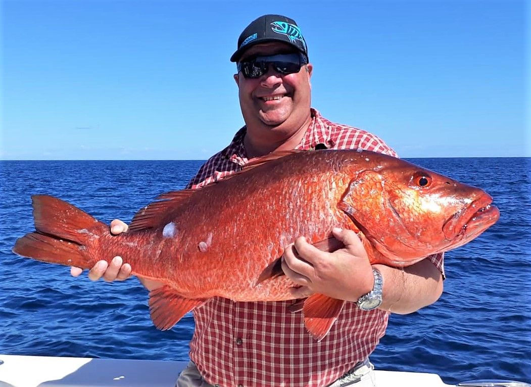 Grinning angler posing with cubera snapper